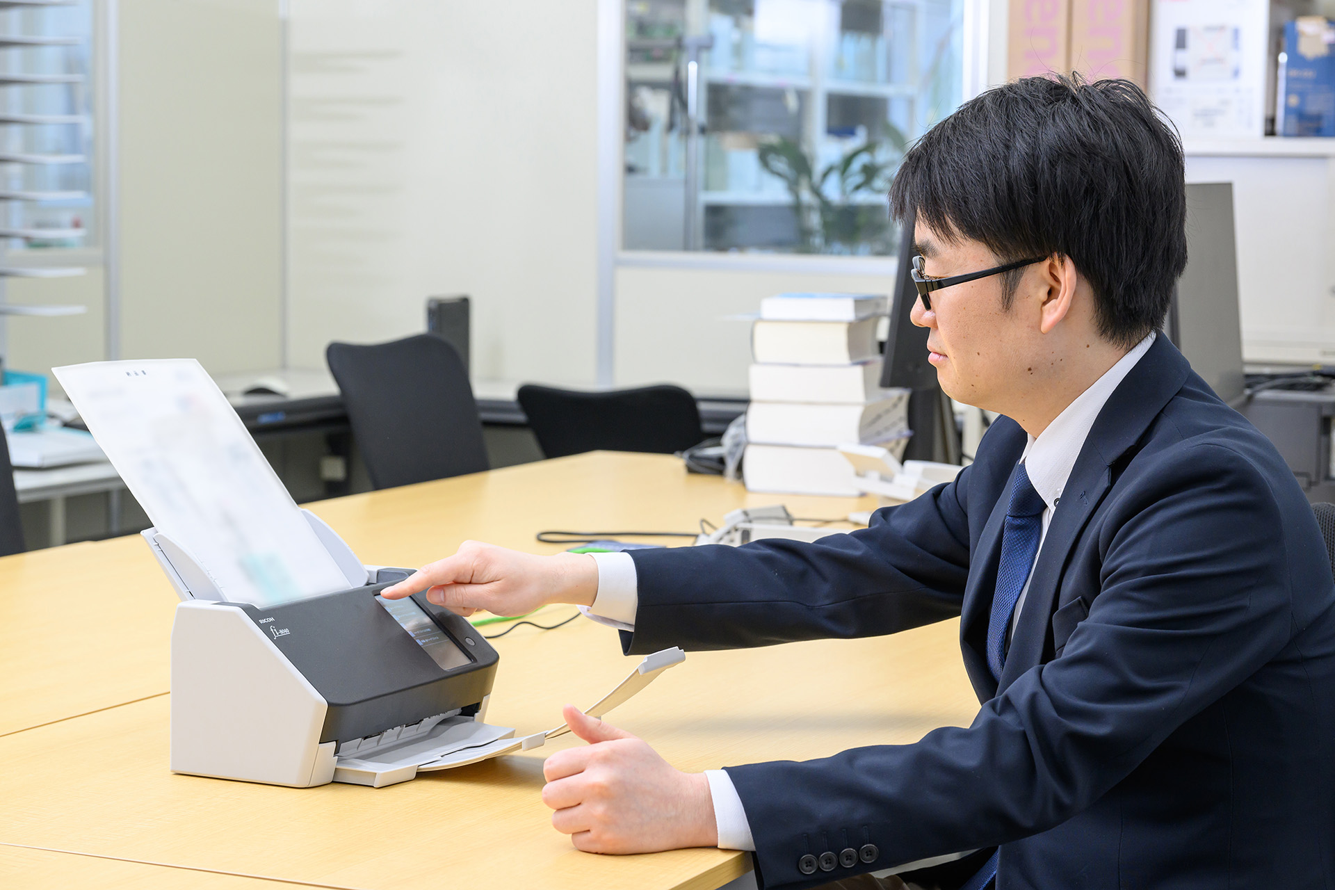 「fi-8040」で紙の証憑をスキャンする様子