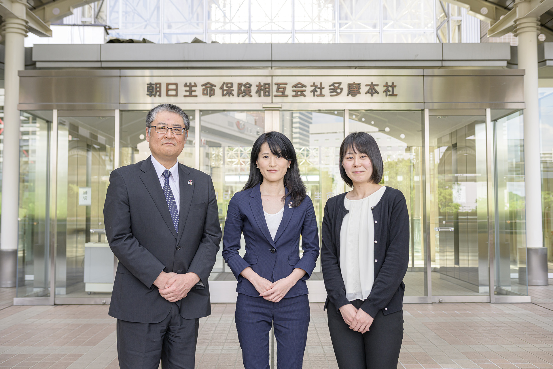 朝日生命保険相互会社多摩本社前の秋山さん、乘本さん、建部さん