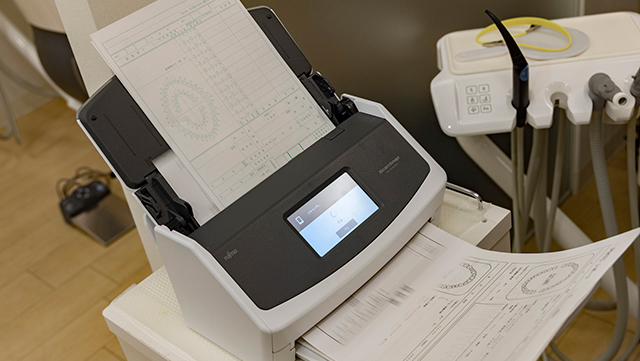 紙のサブカルテを「ScanSnap iX1600」でスキャンする様子）