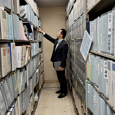 役場内の書庫で資料を探す町民課課長の長（おさ）さん