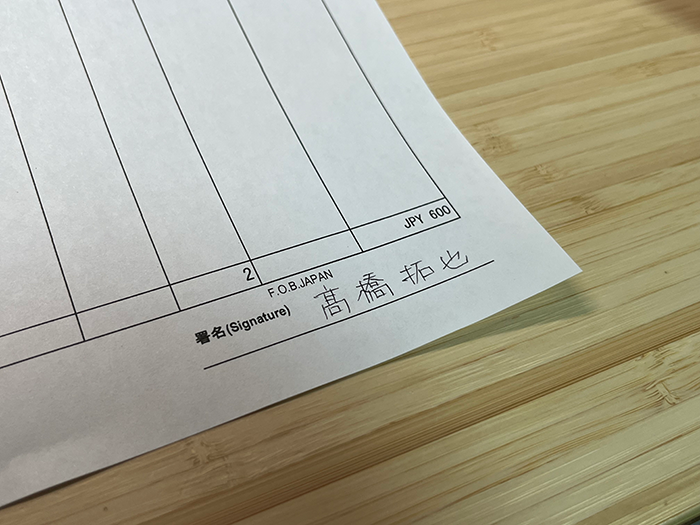 ボールペンで署名した紙