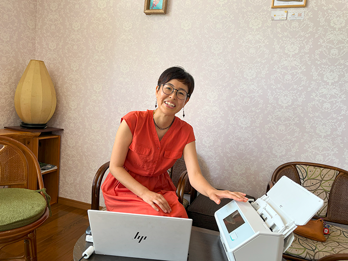 ScanSnap iX2500（白）に手をやる様子の羽立さん