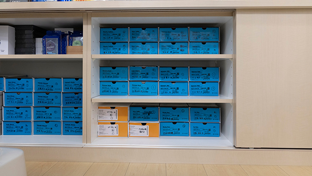 診察室の棚にマウスピースの箱が保管されている様子